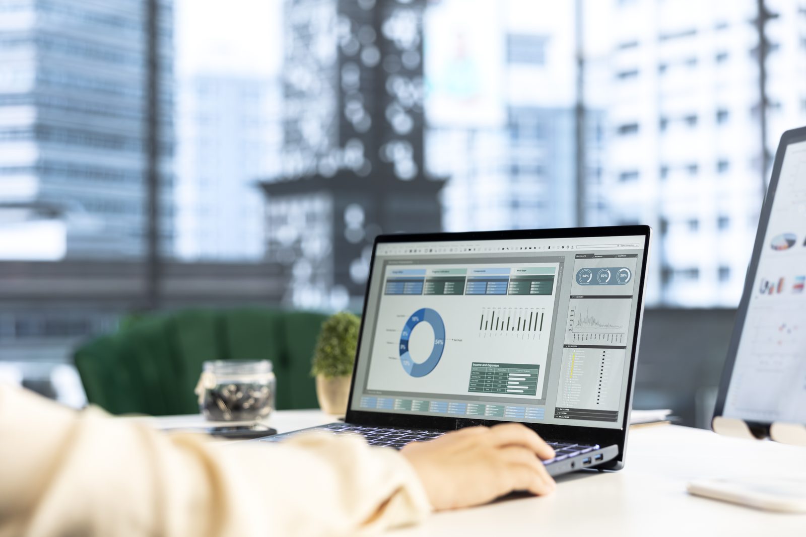 Laptop showing a financial reporting dashboard on a desk in a city office.